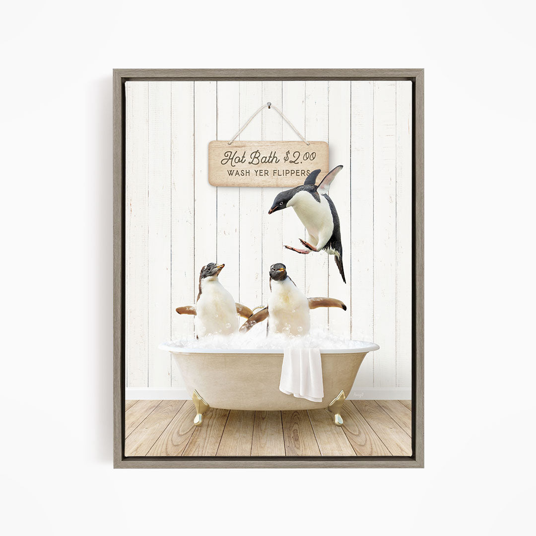 A framed image depicting three penguins sitting in a bathtub, with one penguin flying above the tub and another penguin sitting on the edge of the tub.