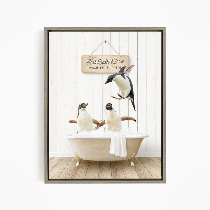 A framed image depicting three penguins sitting in a bathtub, with one penguin flying above the tub and another penguin sitting on the edge of the tub.