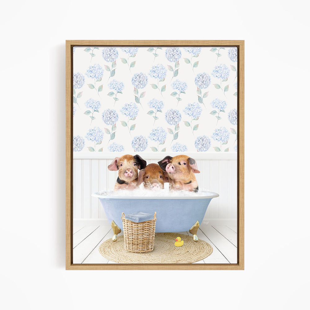 Three adorable pigs sitting in a blue bathtub, surrounded by a wicker basket and rubber duckies, with a floral patterned wall behind them.