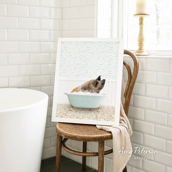 A framed image of a dog sitting in a bathtub, surrounded by a patterned design, is displayed on a wooden chair in a bathroom setting.