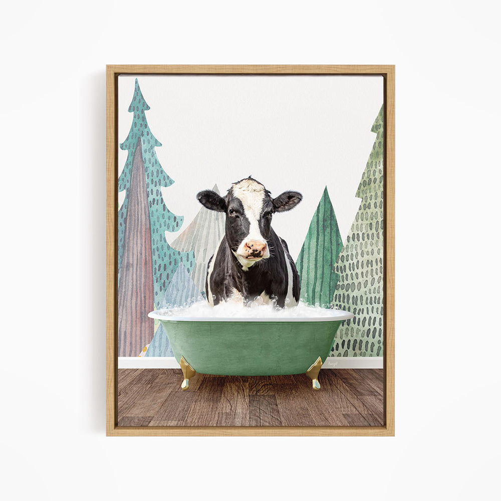 A black and white cow is sitting in a green bathtub, surrounded by trees with green and brown foliage.
