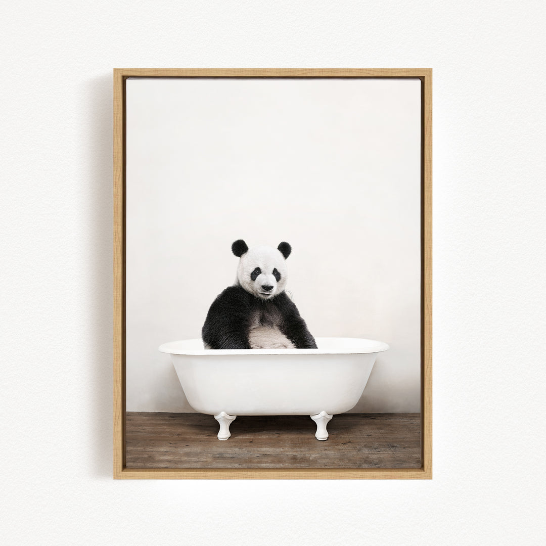 A panda bear sitting in a white bathtub against a plain white background.