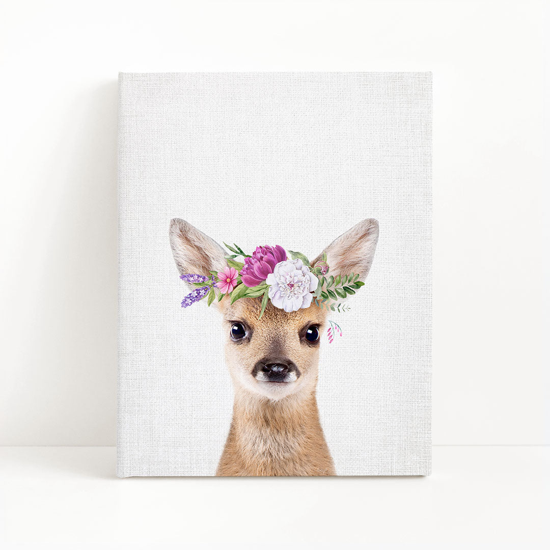 A deer wearing a floral crown on its head, with a white background.