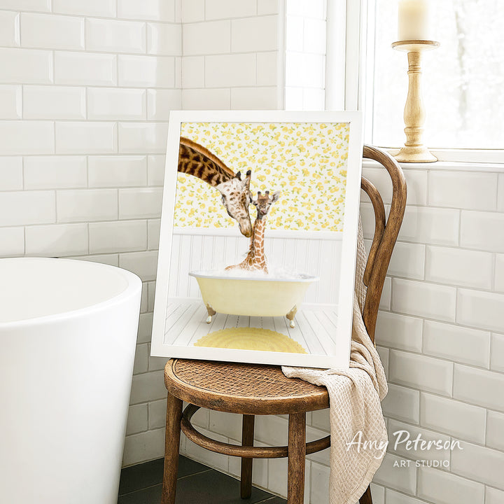 A framed image of two giraffes sitting in a bathtub, with a yellow floral pattern on the walls behind them.