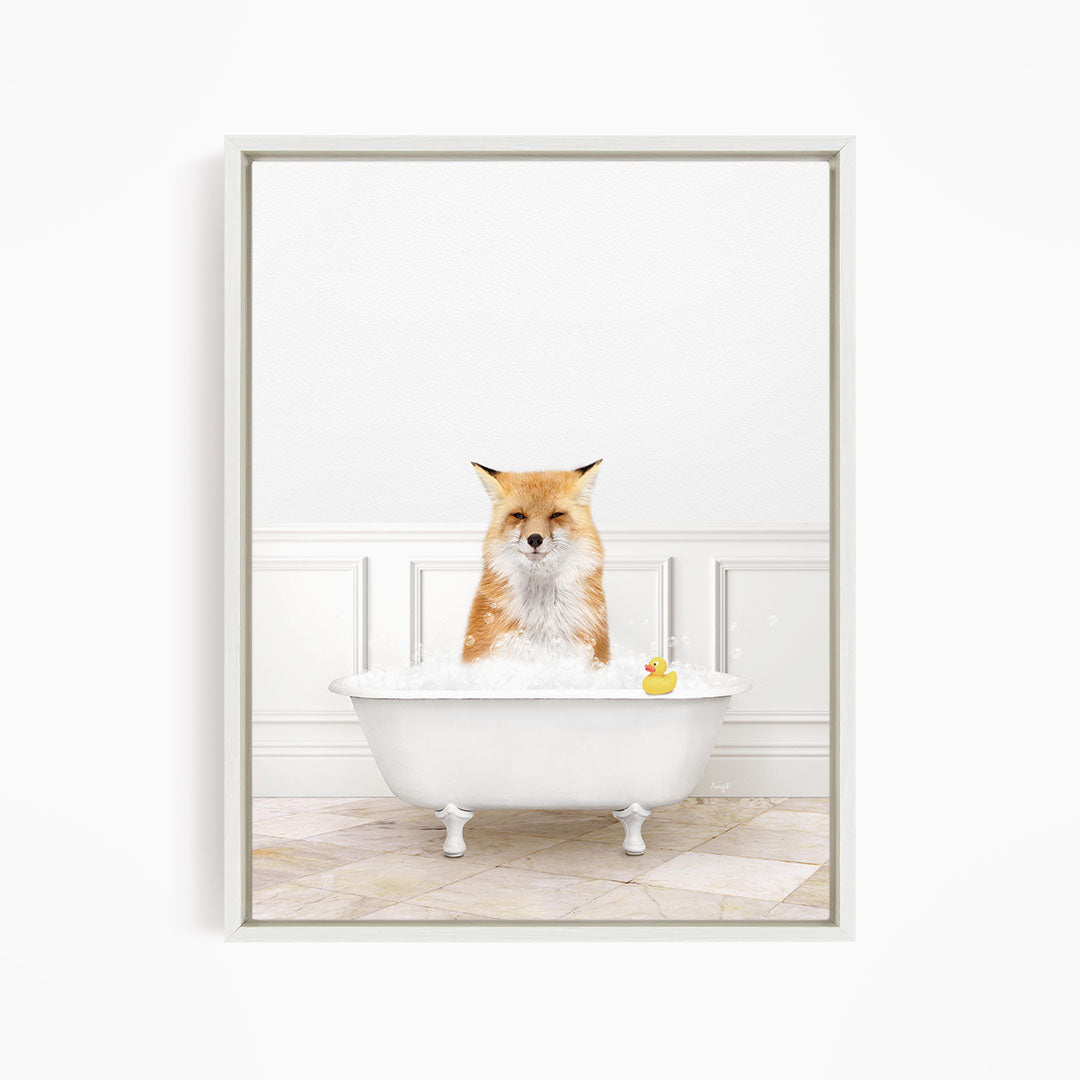 A red fox is sitting in a white bathtub filled with water, with a rubber duck floating in the water.
