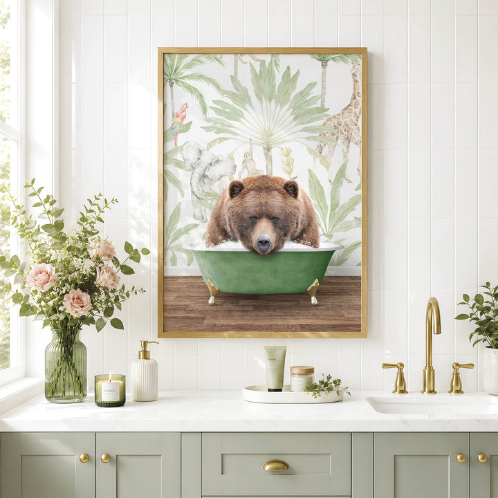 A framed image of a brown bear sitting in a green bathtub, surrounded by a tropical jungle scene, is displayed on a white tiled wall above a bathroom counter with various toiletries and a vase of flowers.