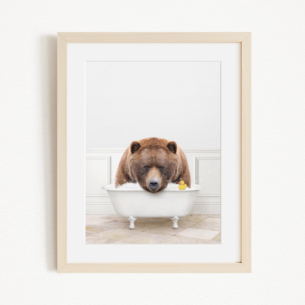 A brown bear is sitting in a white bathtub, surrounded by a yellow rubber duck.