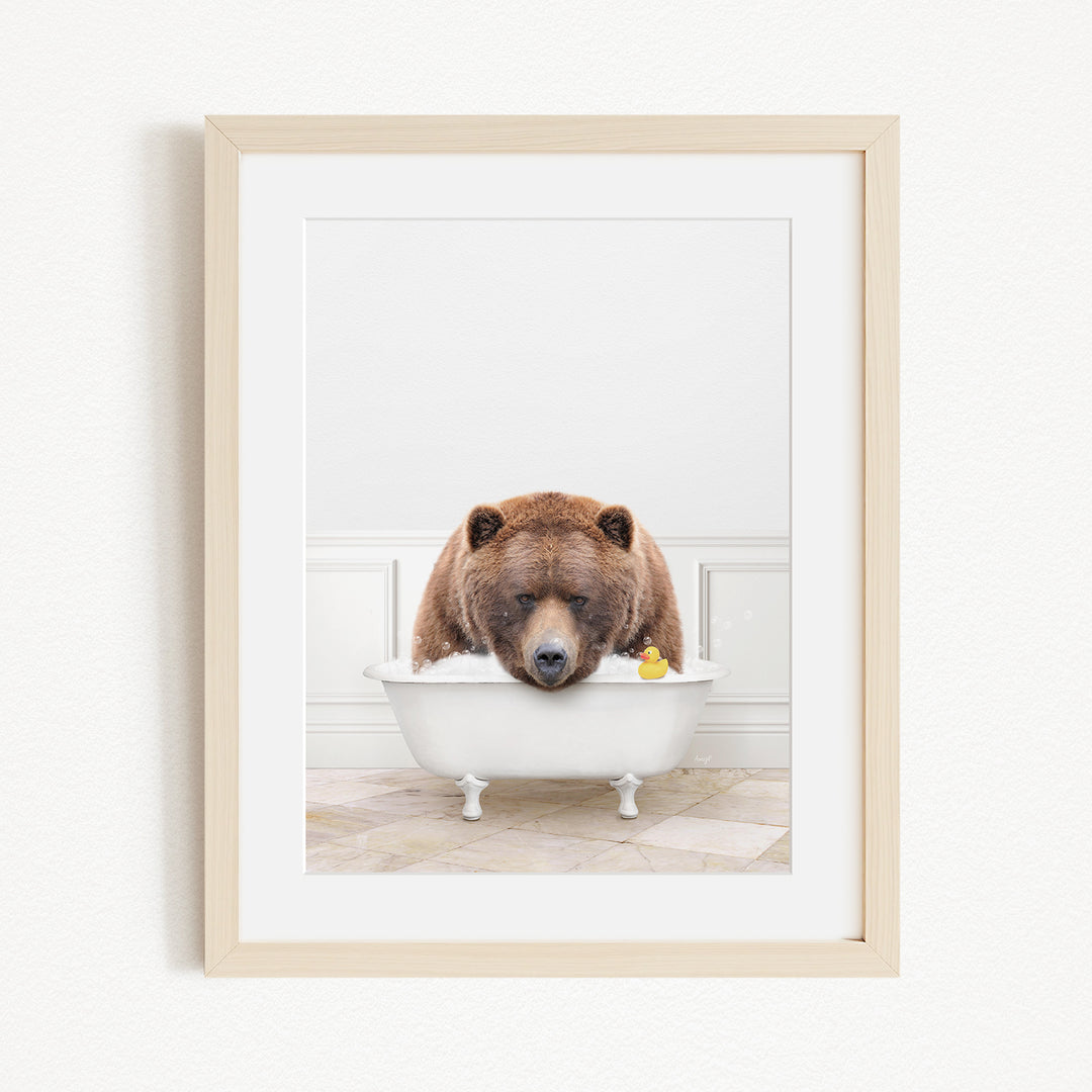 A brown bear is sitting in a white bathtub, surrounded by a yellow rubber duck.