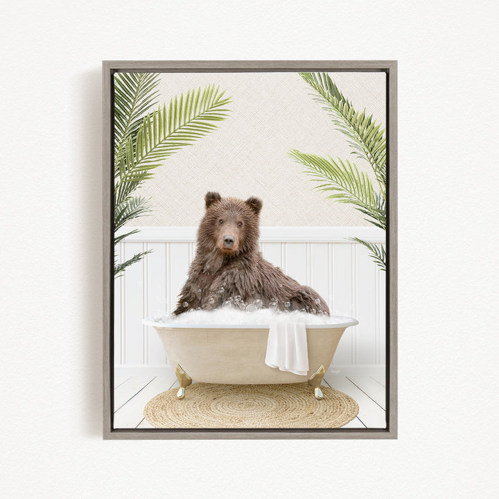 A brown bear sitting in a bathtub filled with bubbles, surrounded by green palm leaves.