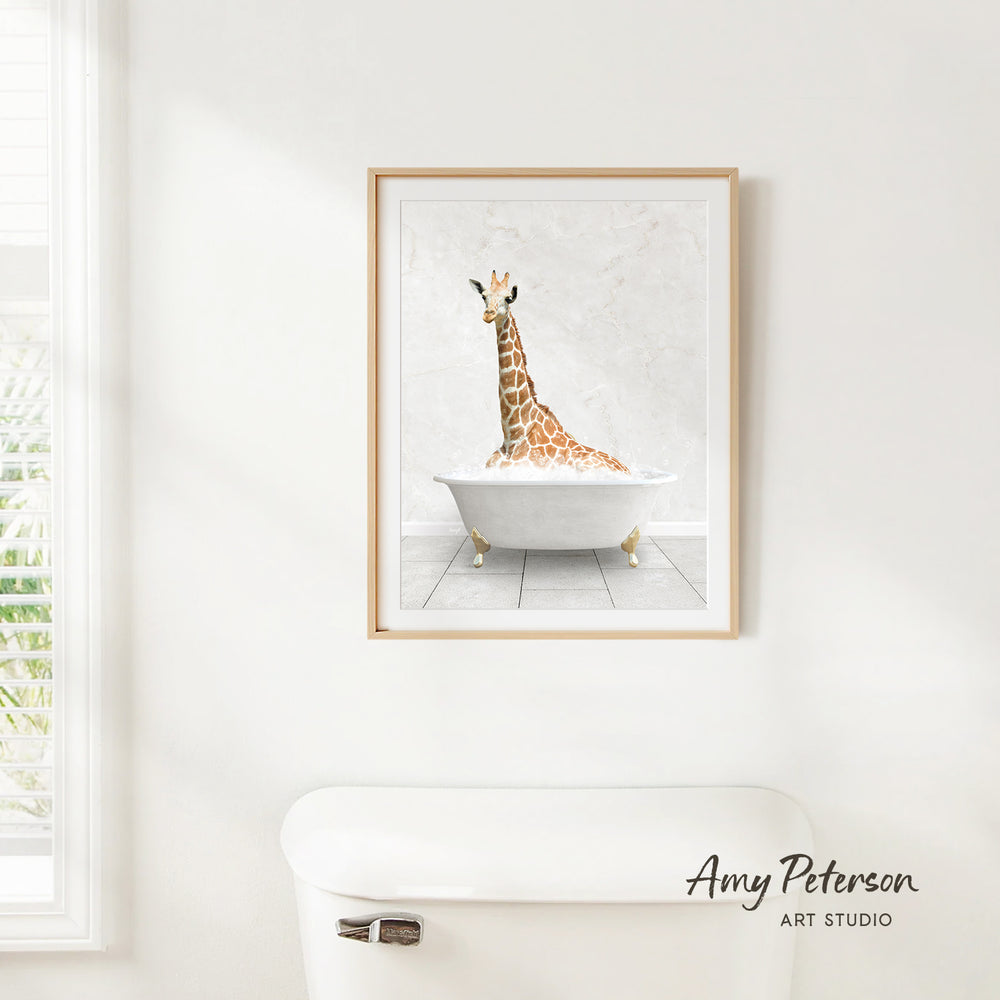A framed painting of a giraffe sitting in a bathtub is hanging on a white wall.