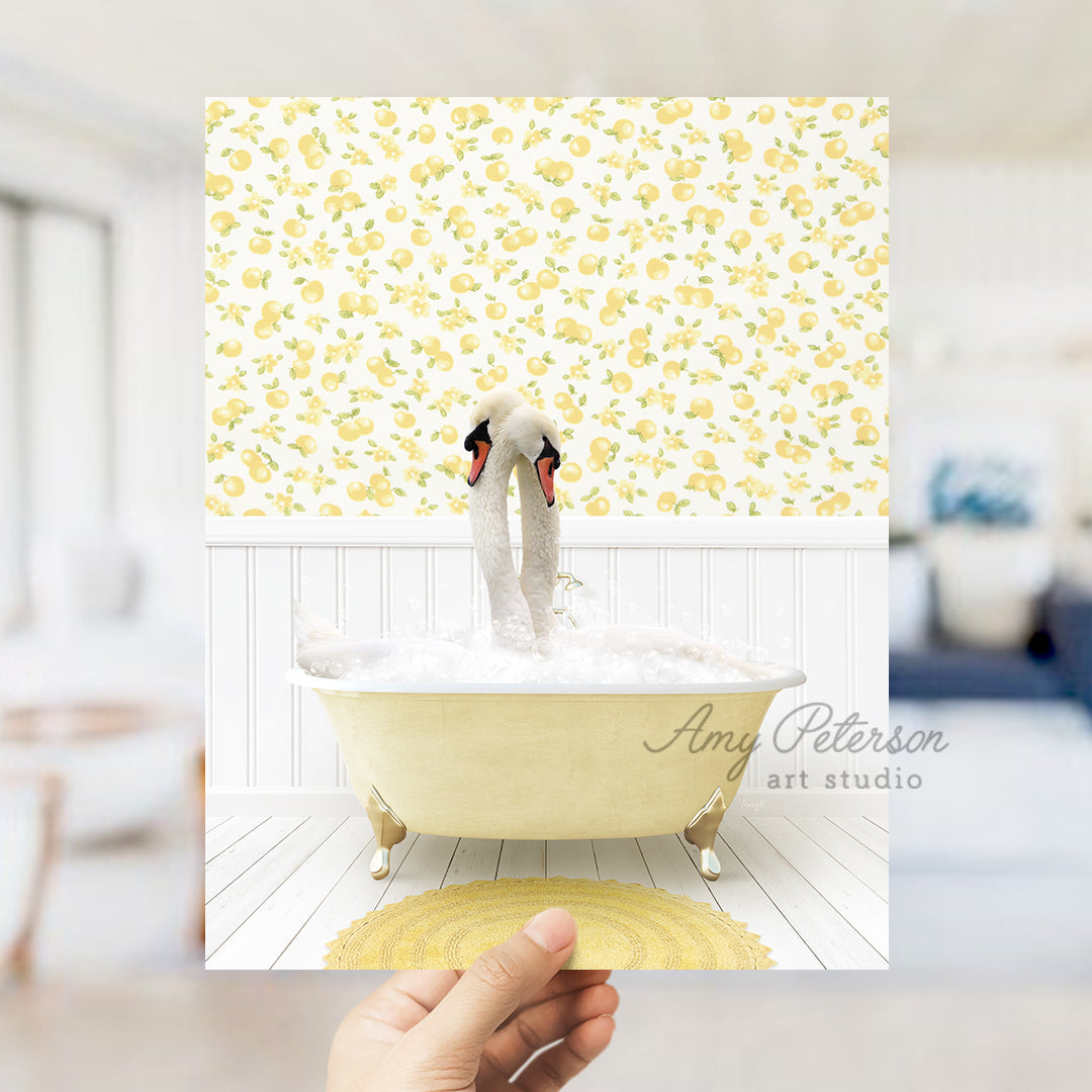 a person holding up a picture of two swans in a bathtub