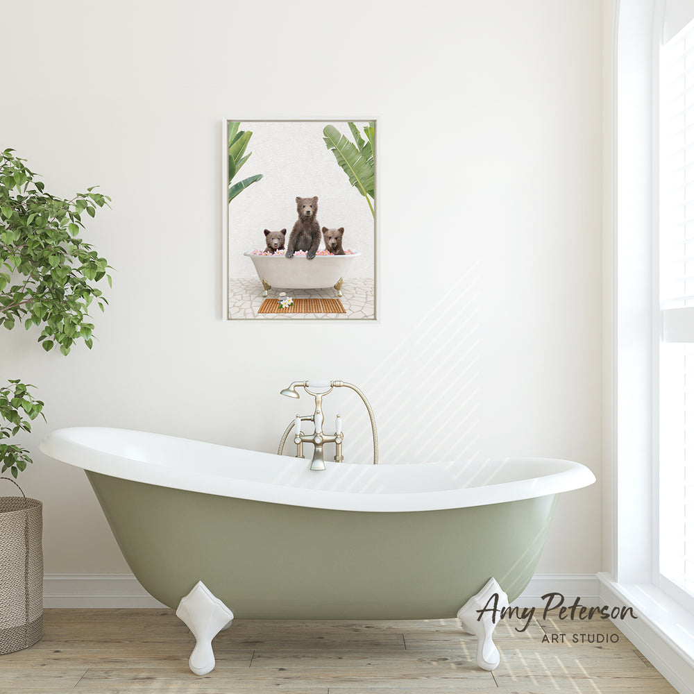 A green clawfoot bathtub with a framed image of two bears sitting in it, hanging on a white wall above it.