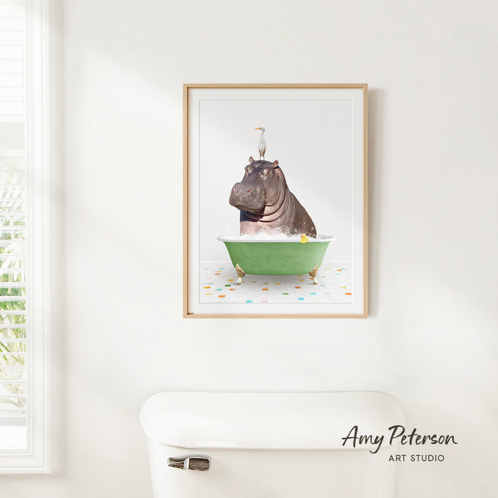 A framed image of a hippopotamus sitting in a green bathtub, with a bird perched on the hippopotamus' head.