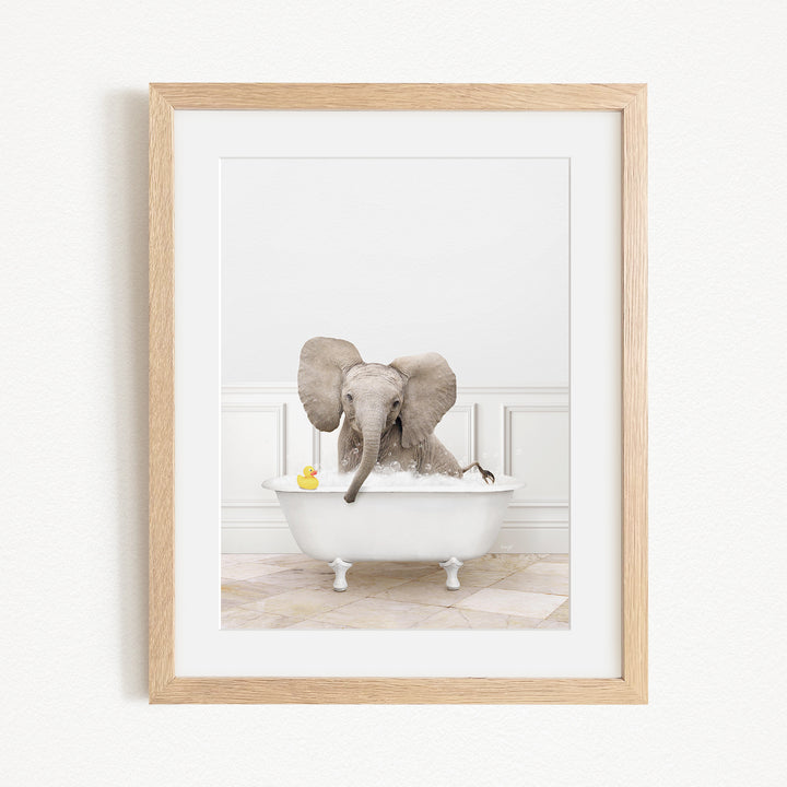 A baby elephant sitting in a white bathtub, surrounded by a yellow rubber duck and a yellow rubber ducky.
