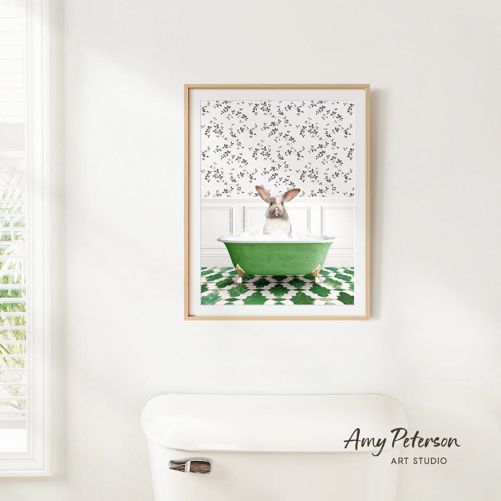 A framed image of a rabbit sitting in a green bathtub, surrounded by a patterned wall and a white toilet in a bathroom setting.