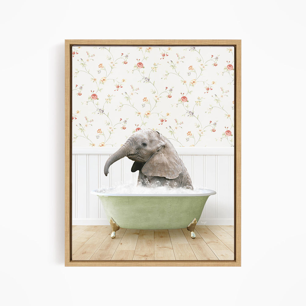 A baby elephant sitting in a green bathtub filled with water, surrounded by a floral wallpaper.