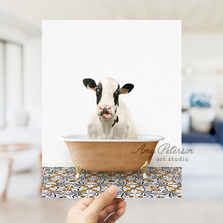 a hand holding a card with a picture of a cow in a bathtub