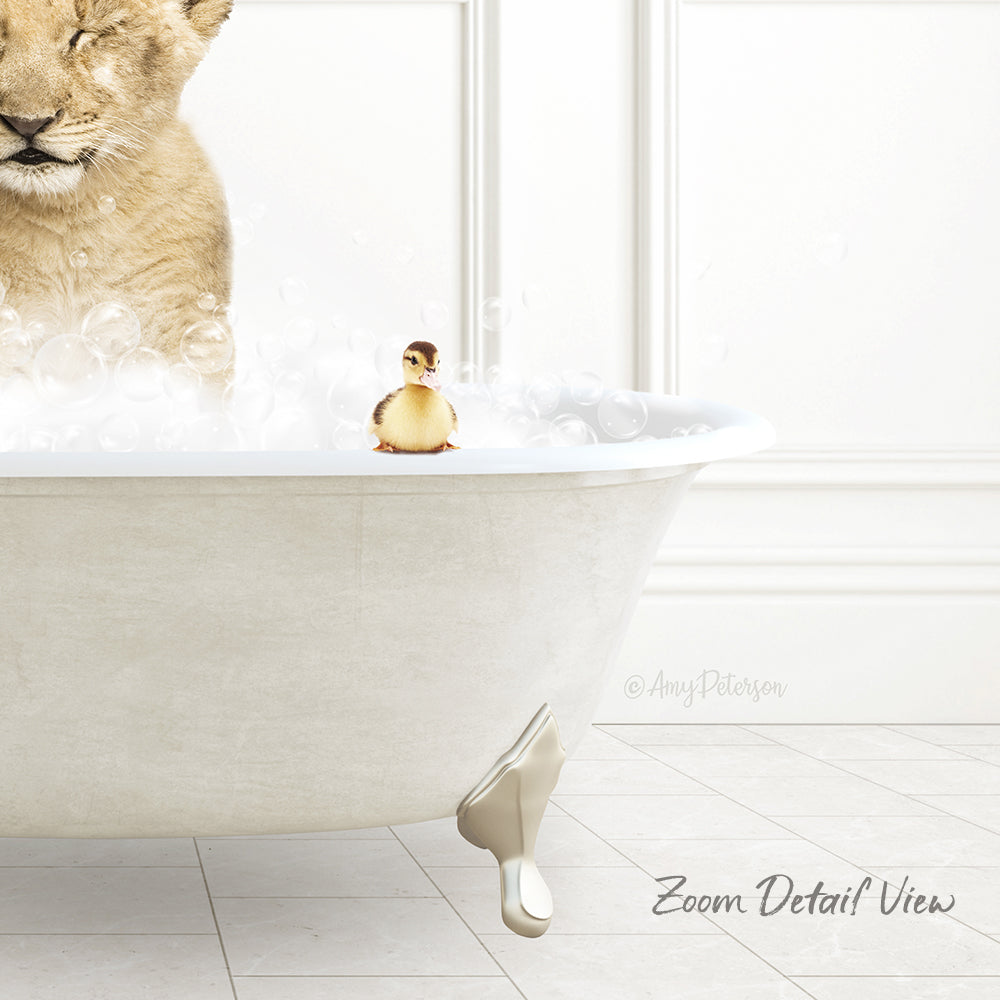 A lion cub is taking a bath in a white bathtub, with a small yellow duck sitting on the edge of the tub.