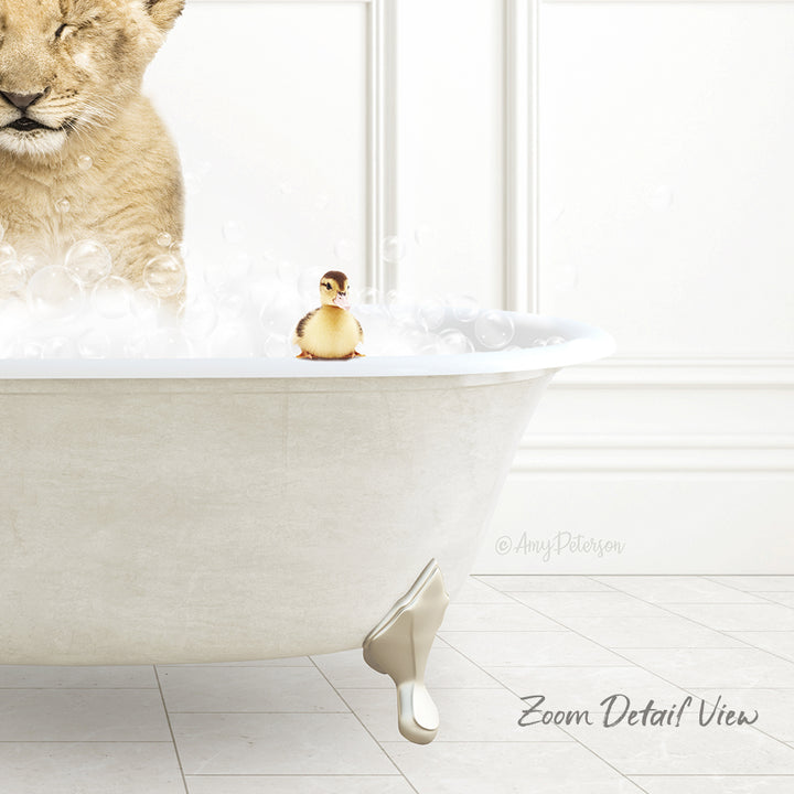 A lion cub is taking a bath in a white bathtub, with a small yellow duck sitting on the edge of the tub.