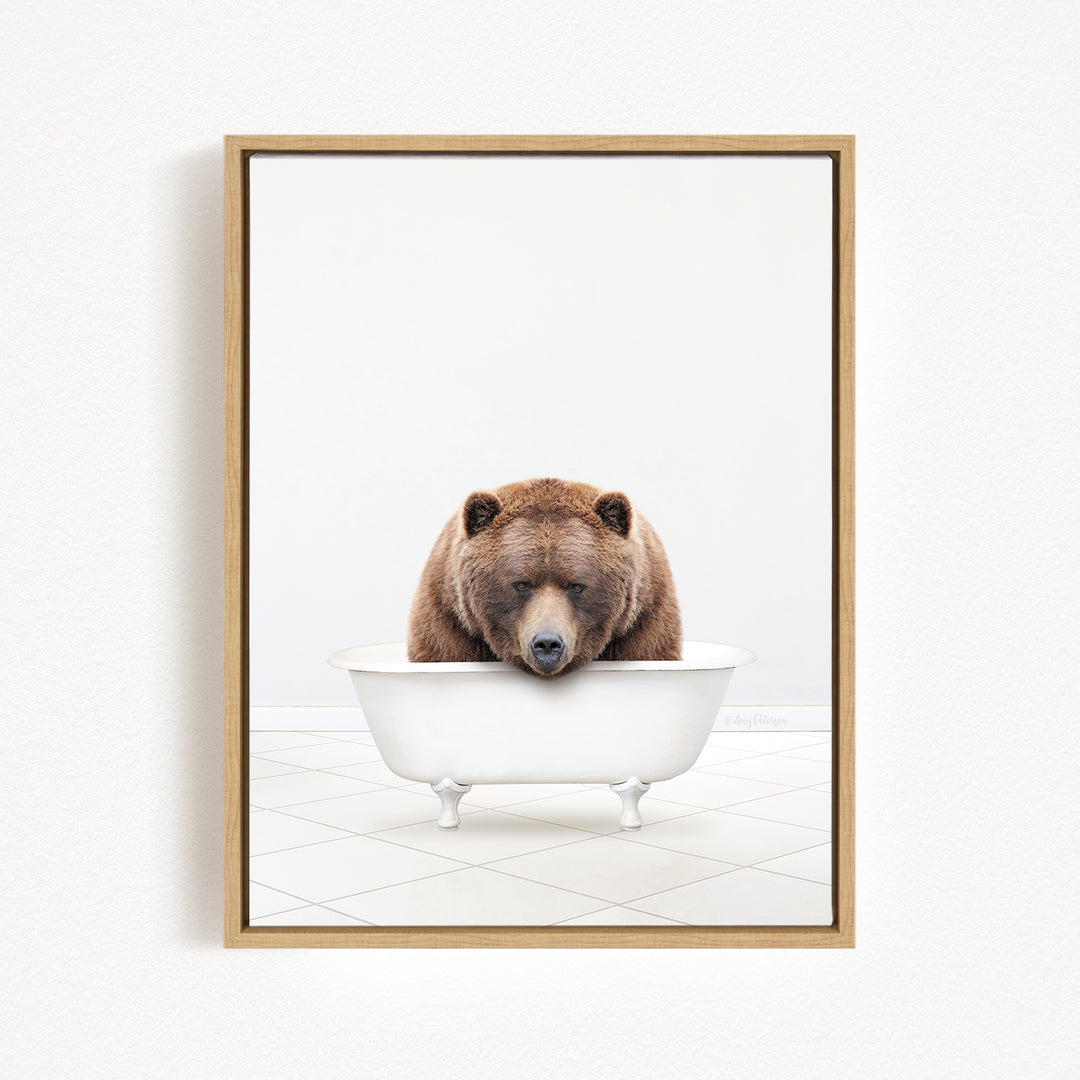 A brown bear is sitting in a white bathtub, appearing to be enjoying a relaxing bath.