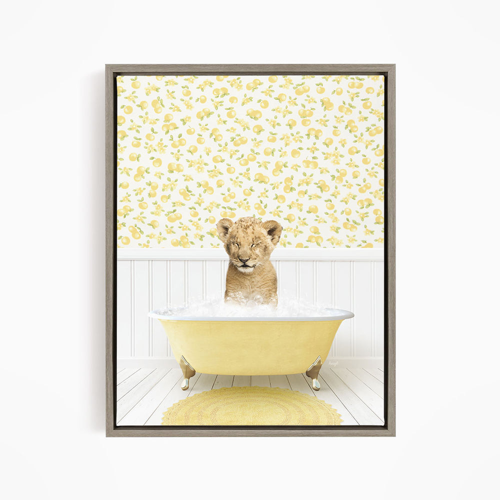 A young lion cub sitting in a yellow bathtub filled with water, surrounded by a yellow floral wallpaper.