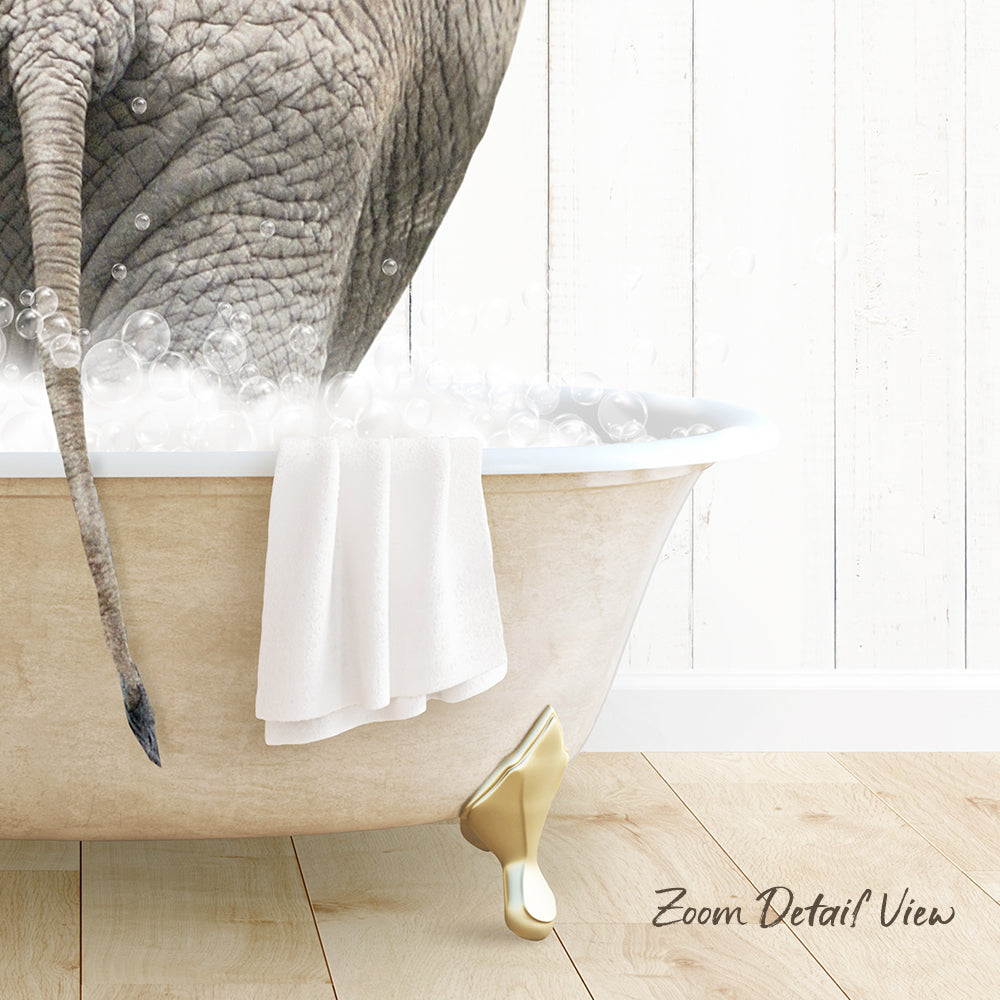 A large elephant is sitting in a bathtub filled with bubbles, with a towel draped over the side of the tub.