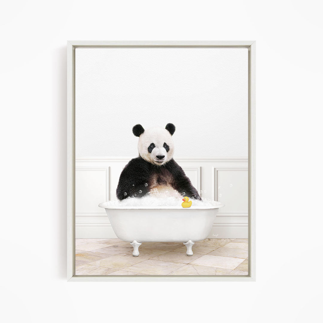 A panda bear sitting in a white bathtub, surrounded by bubbles and a rubber duck.