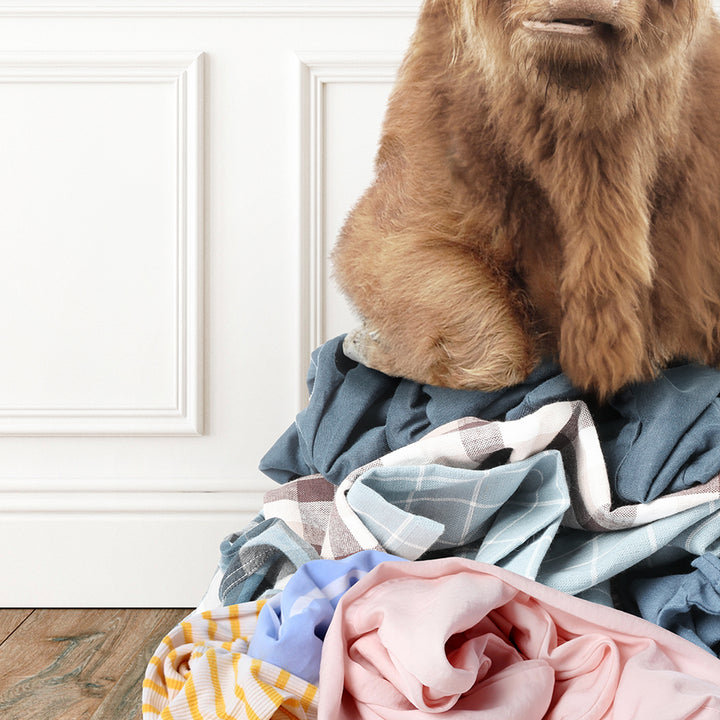 a stuffed bear sitting on top of a pile of clothes