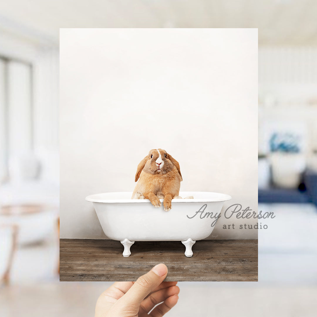 a person holding up a picture of a rabbit in a bathtub