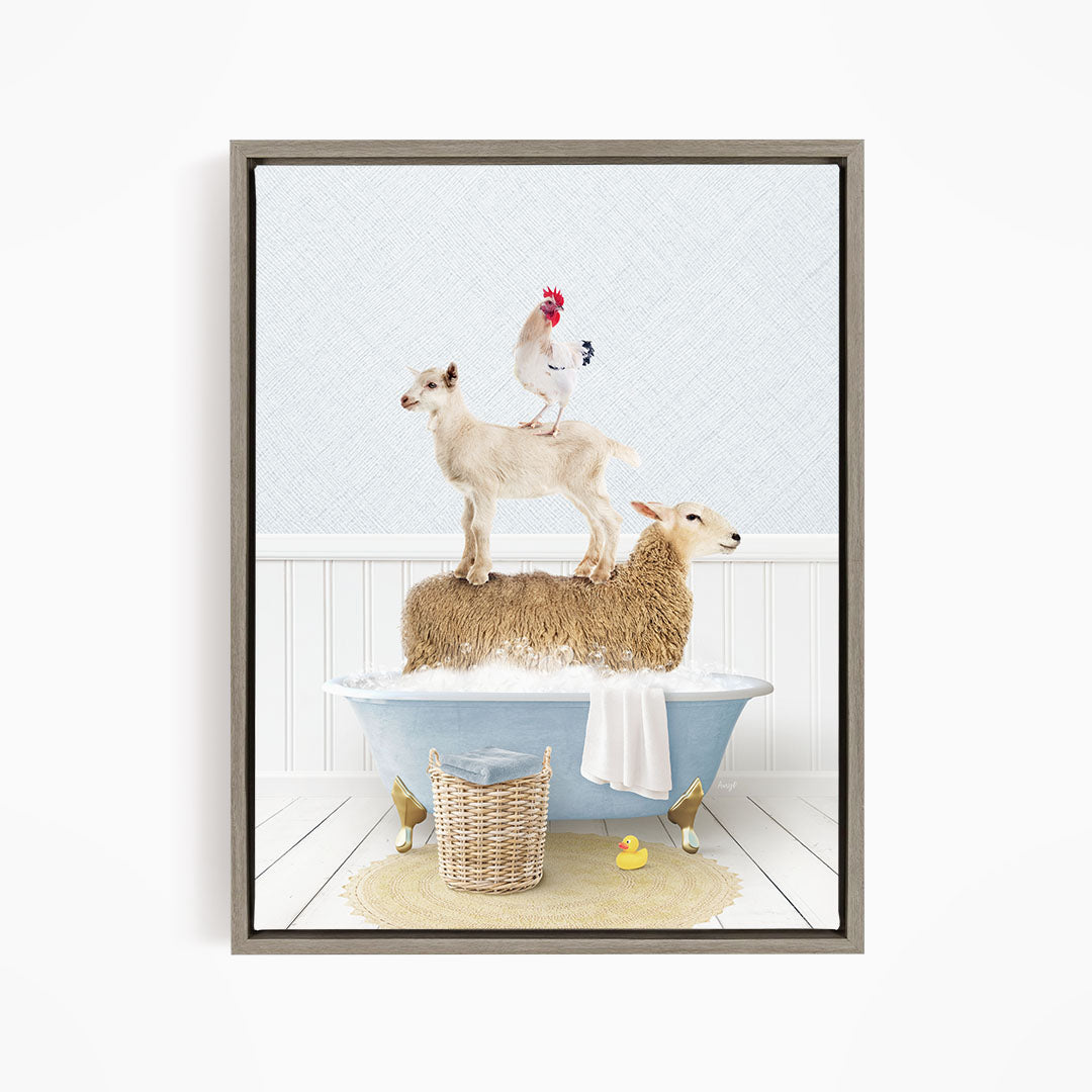 A framed image depicting a sheep standing on a tub filled with bubbles, with a chicken perched on top of the sheep and a lamb standing on the tub's edge.