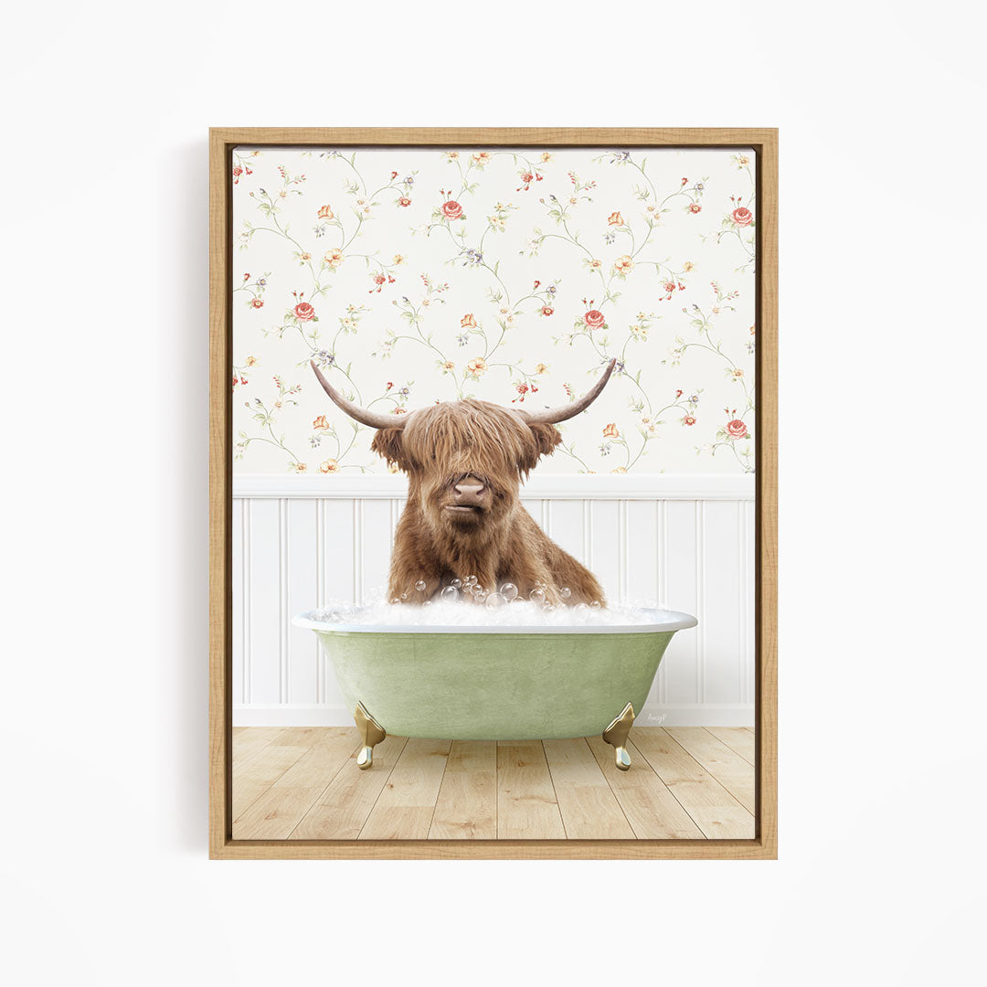 A brown cow with long horns is sitting in a green bathtub filled with water, with a floral wallpaper in the background.