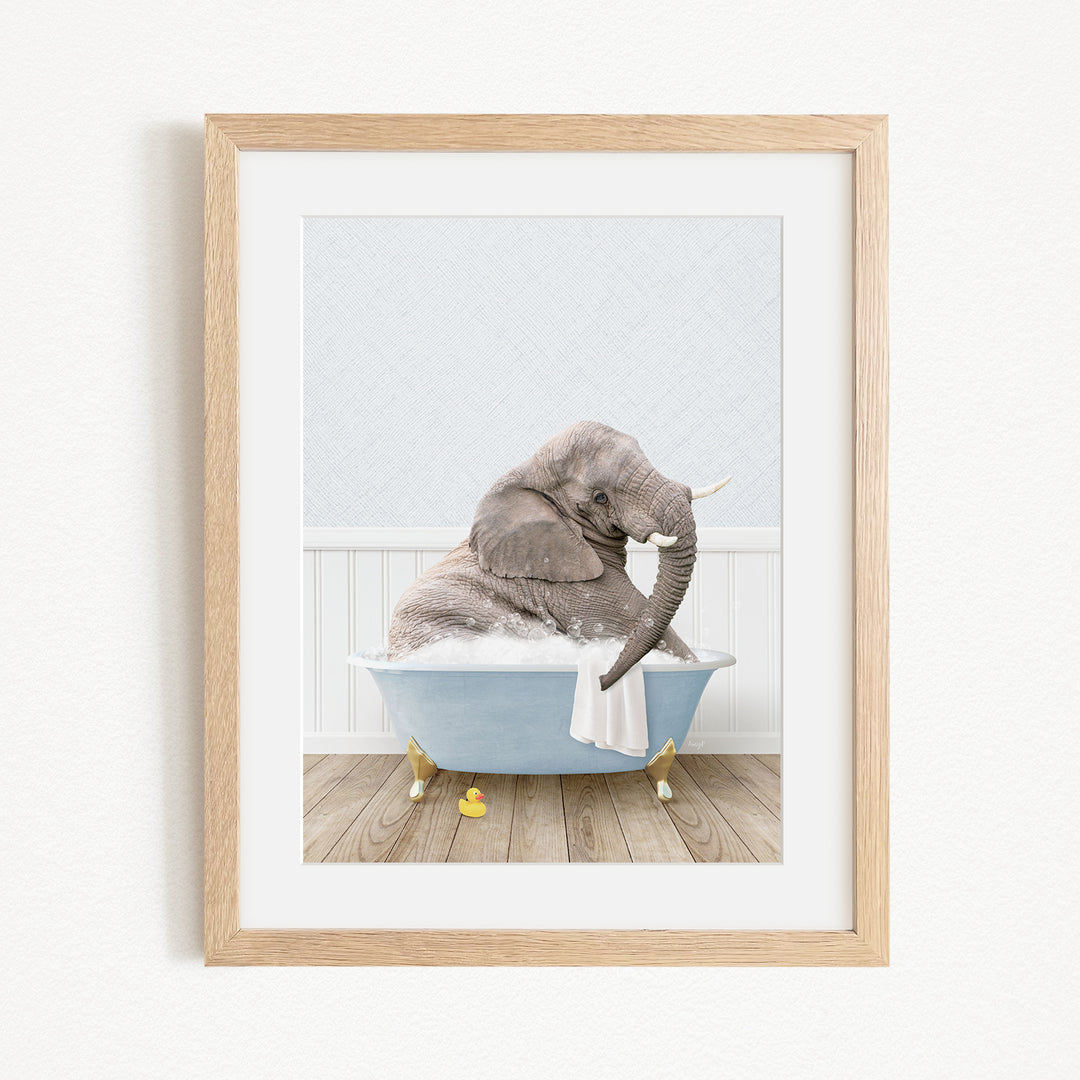 A gray elephant is sitting in a blue bathtub filled with water, surrounded by yellow rubber duckies.