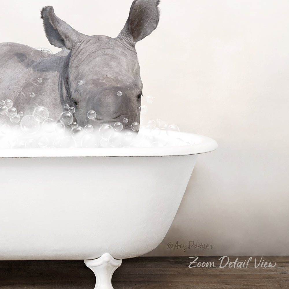 A rhinoceros is sitting in a white bathtub filled with bubbles, creating a whimsical and playful scene.
