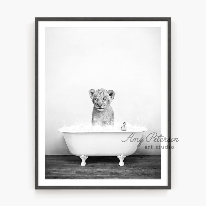 a black and white photo of a baby tiger in a bathtub