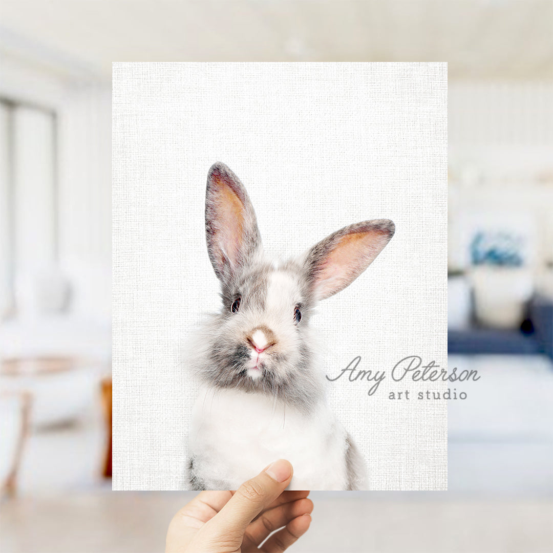 a person holding up a card with a picture of a rabbit