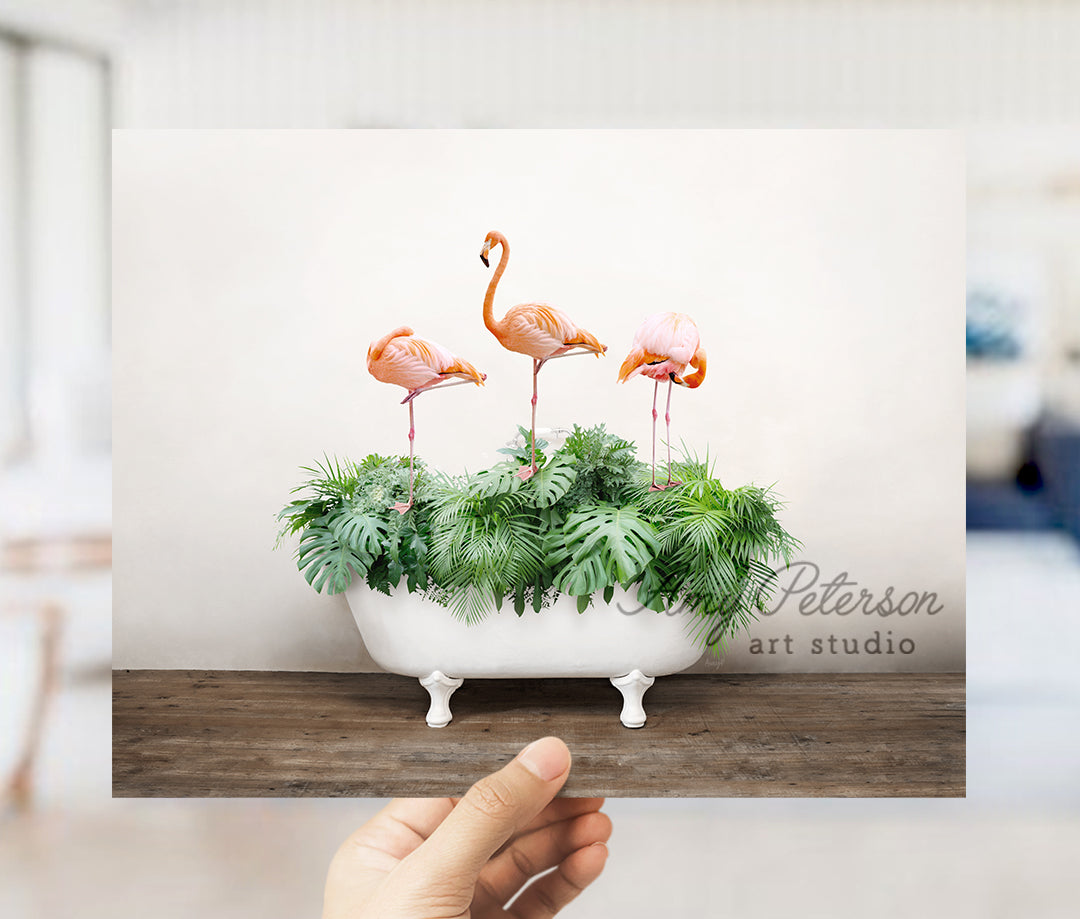 a hand holding a card with three flamingos in a planter