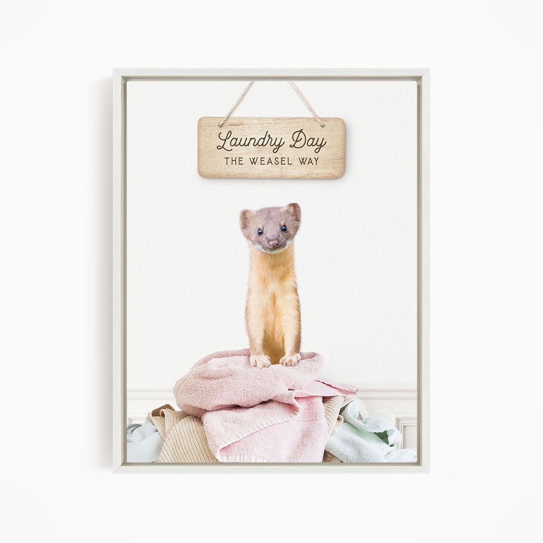 A weasel standing on a pile of clothes with a wooden sign above it that says "Laundry Day The Weasel Way".