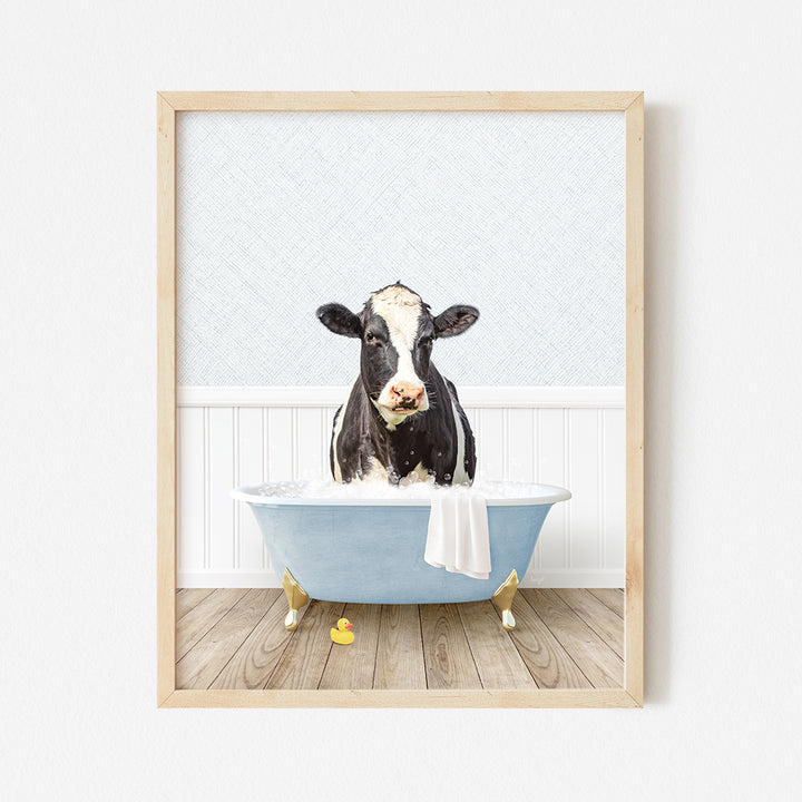 a black and white cow sitting in a bathtub