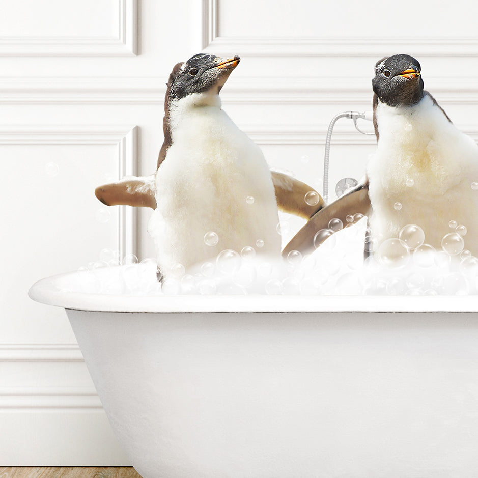 two penguins sitting in a bathtub full of bubbles