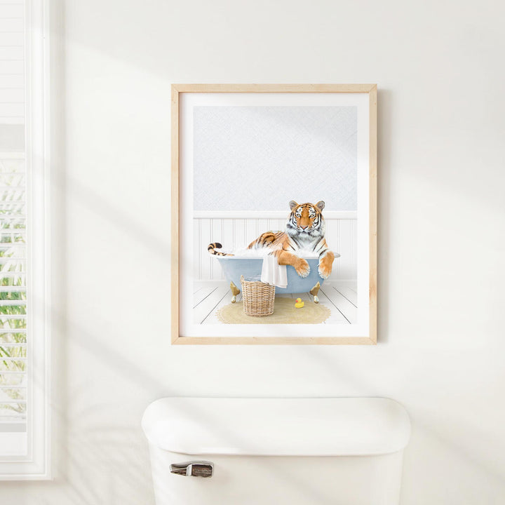 A framed image of a tiger sitting in a bathtub, surrounded by various objects, including a basket and a towel.