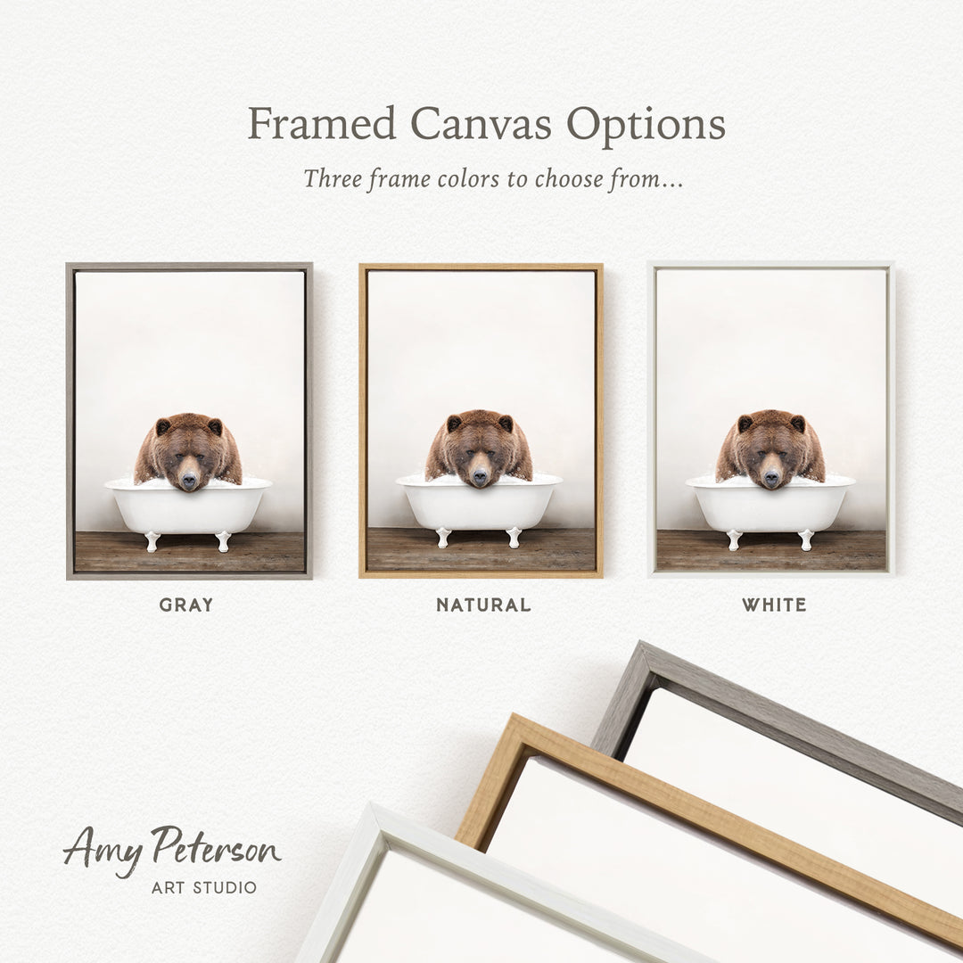 three framed canvas options, each featuring a brown bear sitting in a white bathtub. The options include a gray frame, a natural frame, and a white frame.