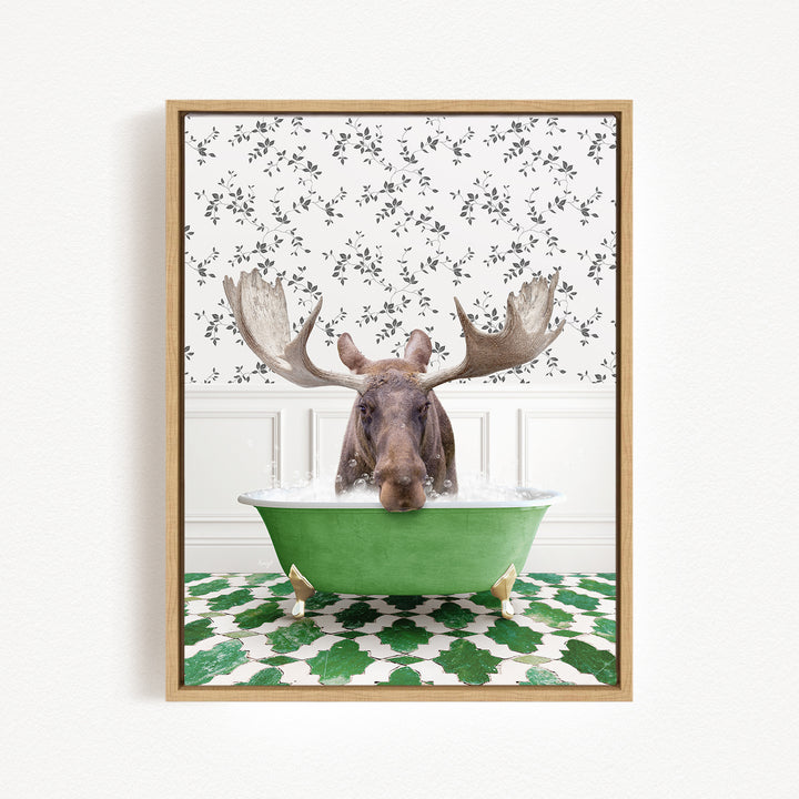 A moose with large antlers is sitting in a green bathtub filled with water, surrounded by a patterned wall and green and white tiles on the floor.