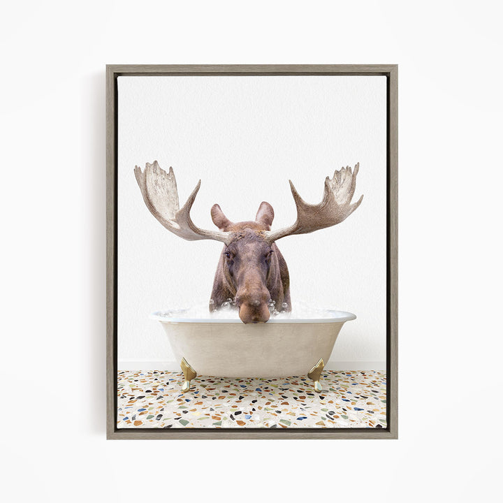 A moose with large antlers is sitting in a bathtub filled with water, creating a whimsical and humorous scene.