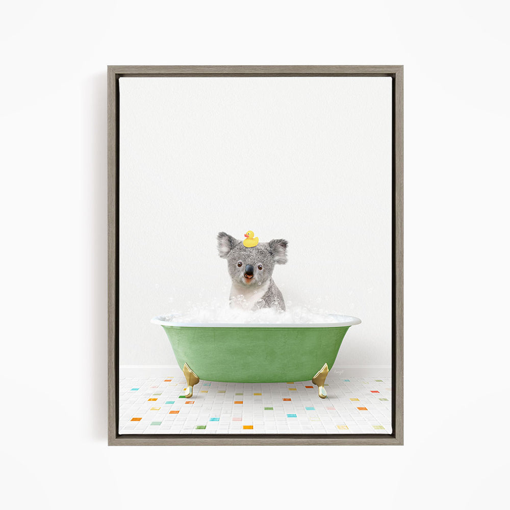 A koala bear sitting in a green bathtub filled with bubbles, wearing a yellow rubber duck hat.