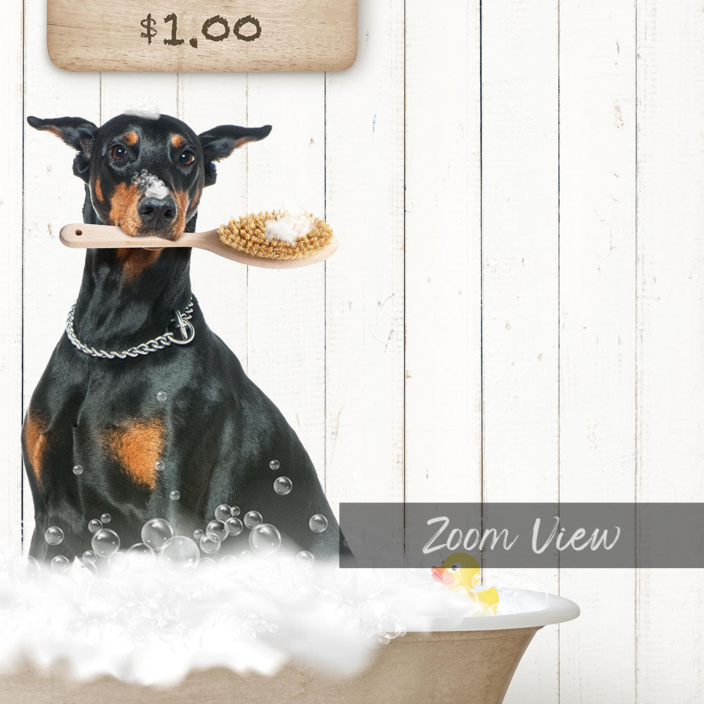 A black and brown dog is sitting in a bathtub filled with bubbles, holding a wooden brush in its mouth.