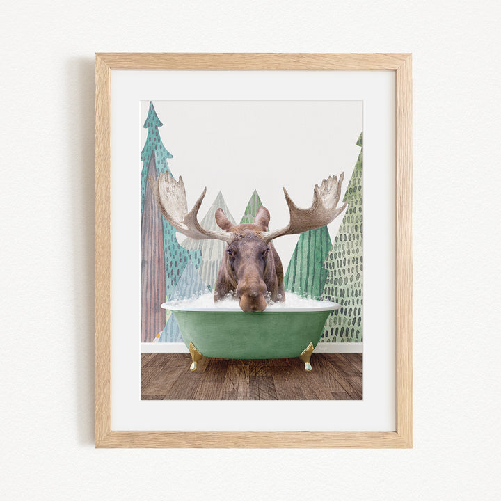 A moose with large antlers is sitting in a green bathtub, surrounded by a forest scene with trees and a snowy landscape.