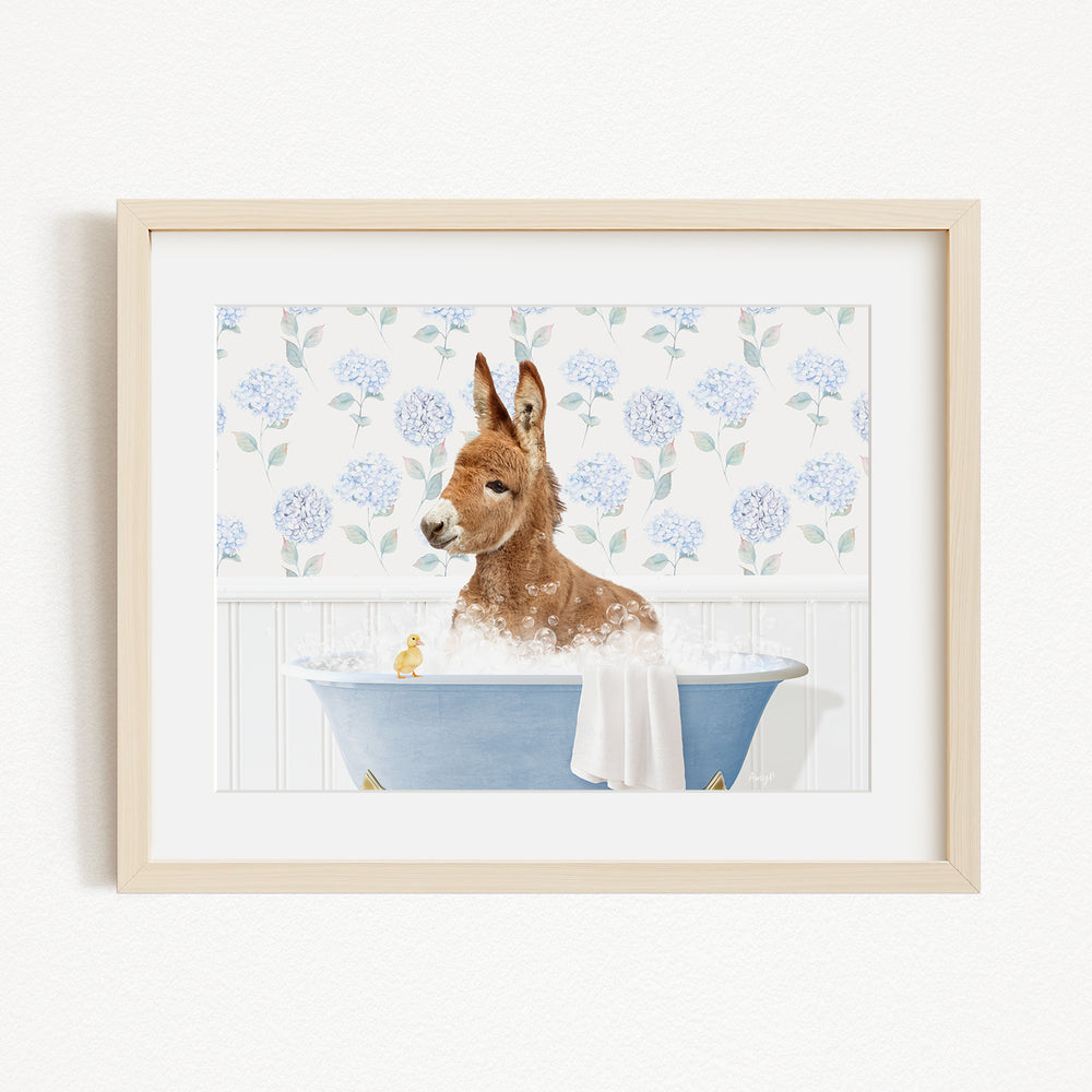 A brown dog is sitting in a blue bathtub filled with bubbles, surrounded by a floral pattern on the wall behind it.