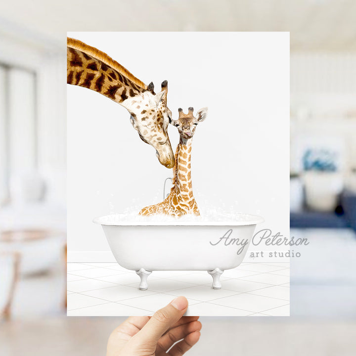 a hand holding up a card with two giraffes in a bathtub