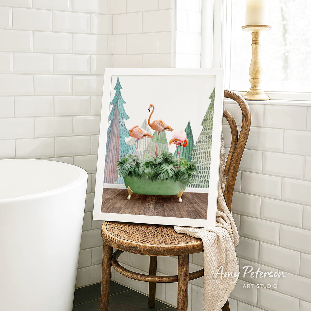 A framed print of a vibrant painting of three flamingos in a green vase is displayed on a wooden chair in a bathroom setting.