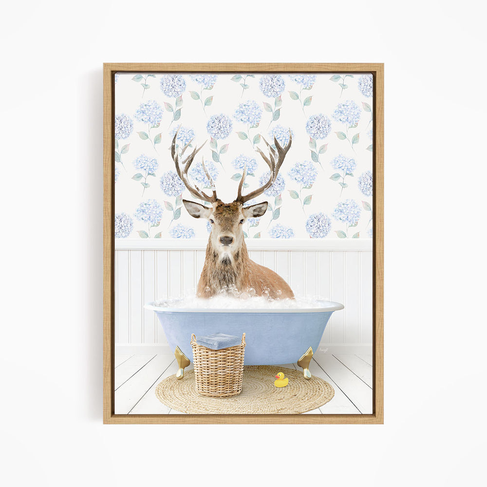 A deer with antlers is sitting in a blue bathtub filled with bubbles, surrounded by a wicker basket and rubber ducks.